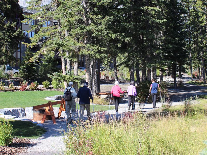 A group of seniors walk along a path at Origin at Spring Creek to stay active in retirement living.