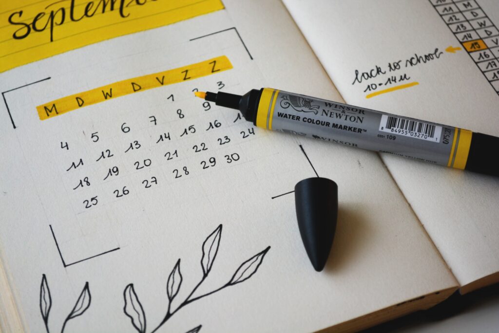 A planner is open to the month of September, with a yellow highlighter on top of the page, and the month highlighted in yellow.